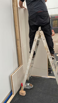 Handwerker montiert Blockelemente auf einer Leiter